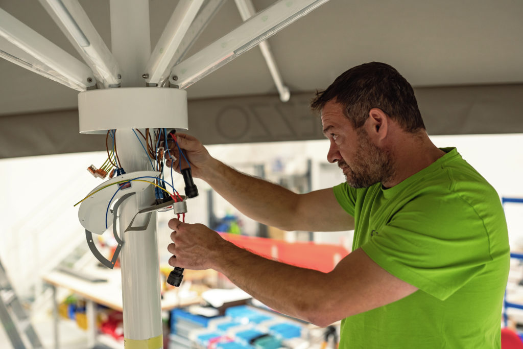Mitarbeiter arbeitet an Elektrik von CARAVITA Sonnenschirm