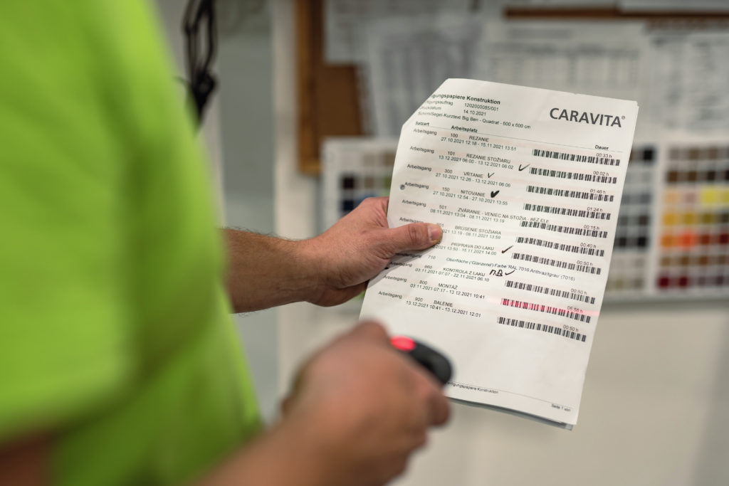 Mitarbeiter kontrolliert Checkliste für CARAVITA Sonnenschirm