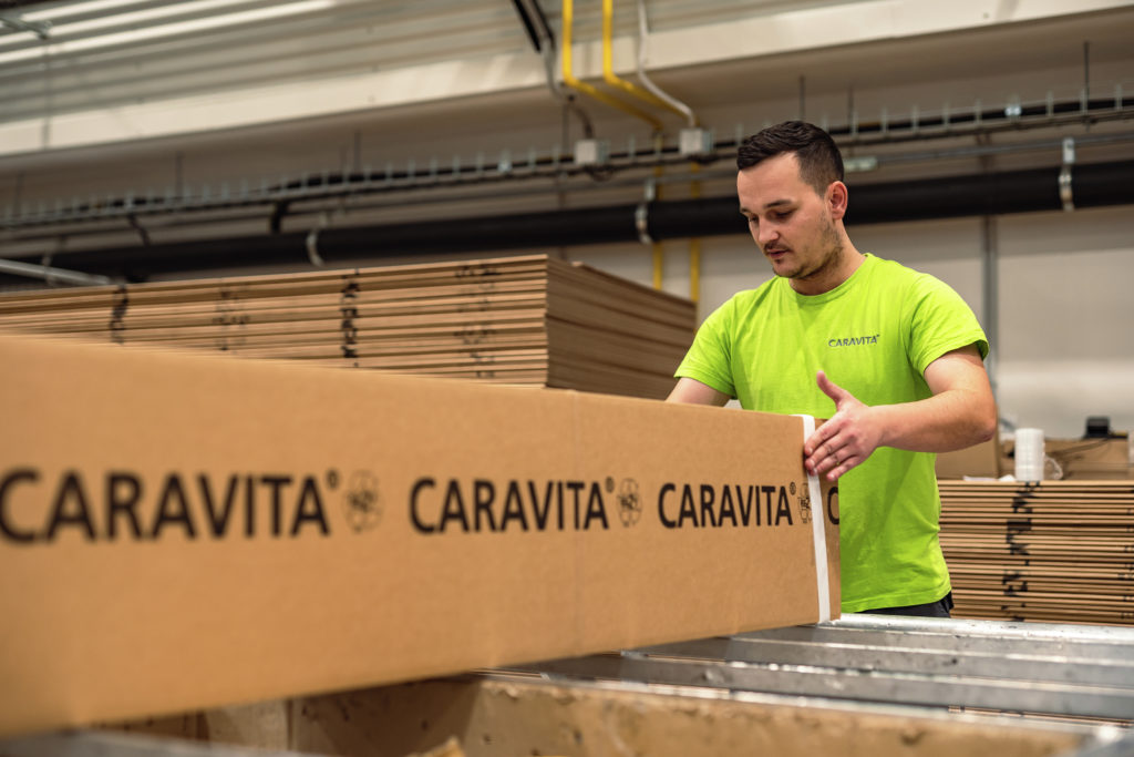 Mitarbeiter verpackt CARAVITA Sonnenschirm in stabilen Karton