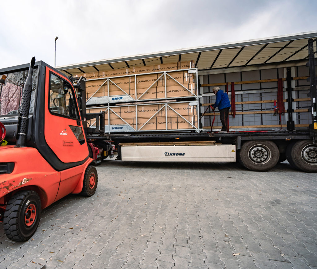 LKW lädt verpackte CARAVITA Sonnenschirme auf