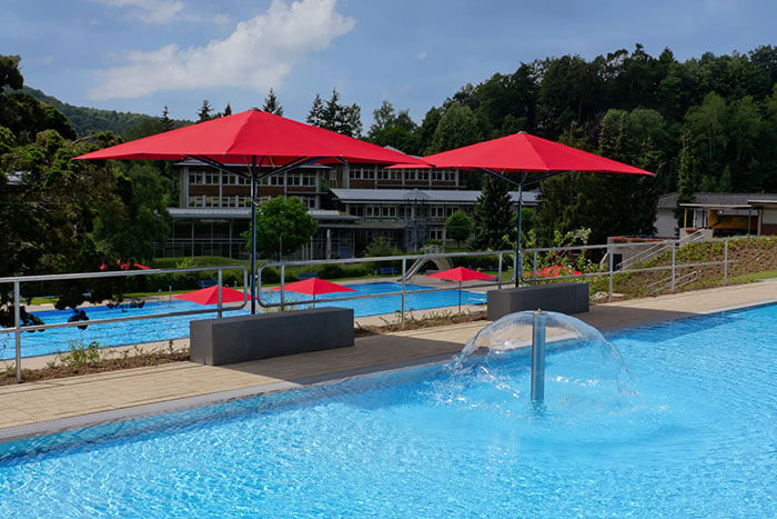 Rote CARAVITA Sonnenschirme in Schwimmbad